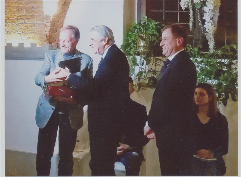 Il giornalista Franco Morabito al centro e il sindaco di Scarperia Federico Ignesti a destra premiano l’allenatore  di calcio Renzo Ulivieri.